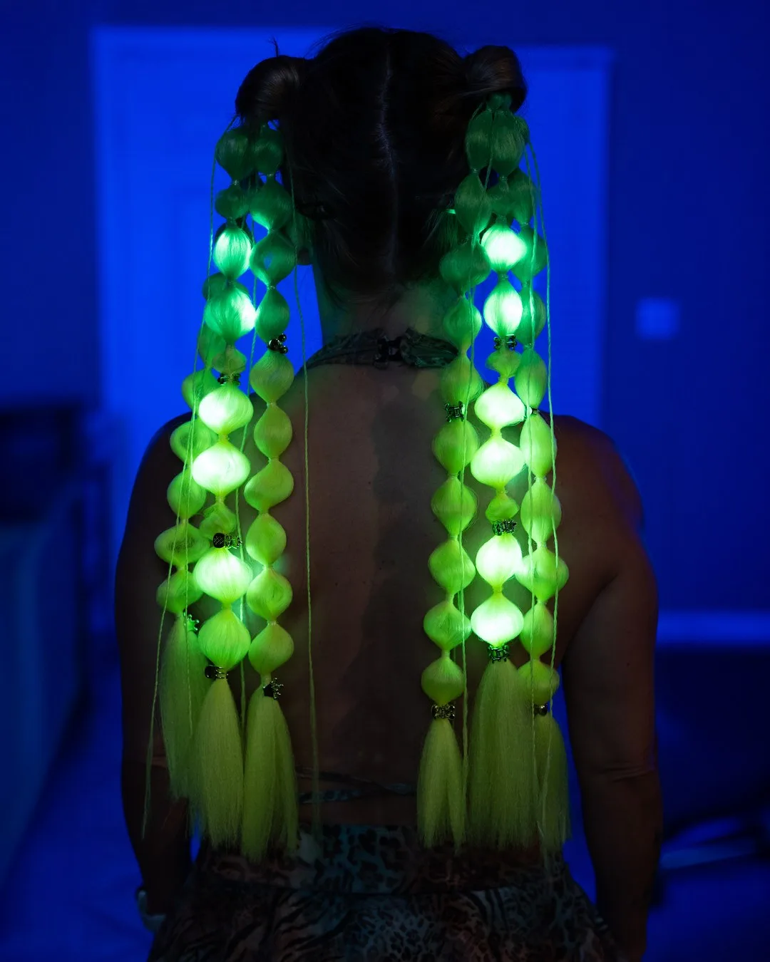 Model wearing neon green LED hair extensions glowing electric green