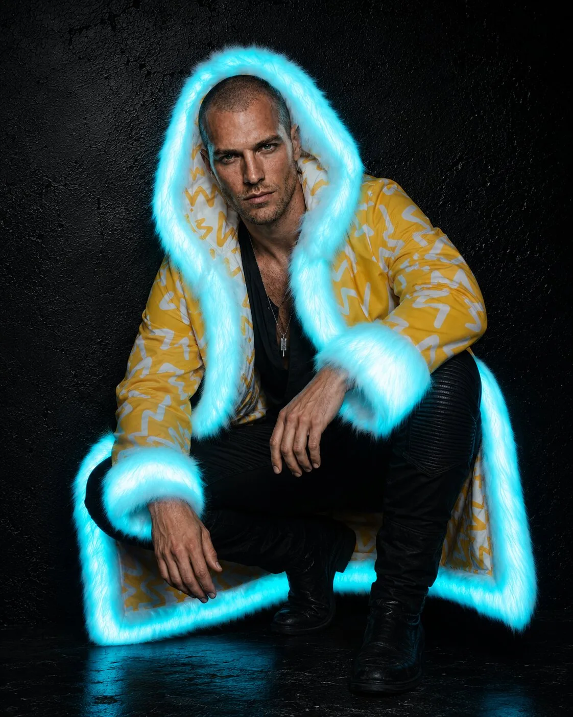 Men's yellow and white LED fur coat glowing cyan, crouching